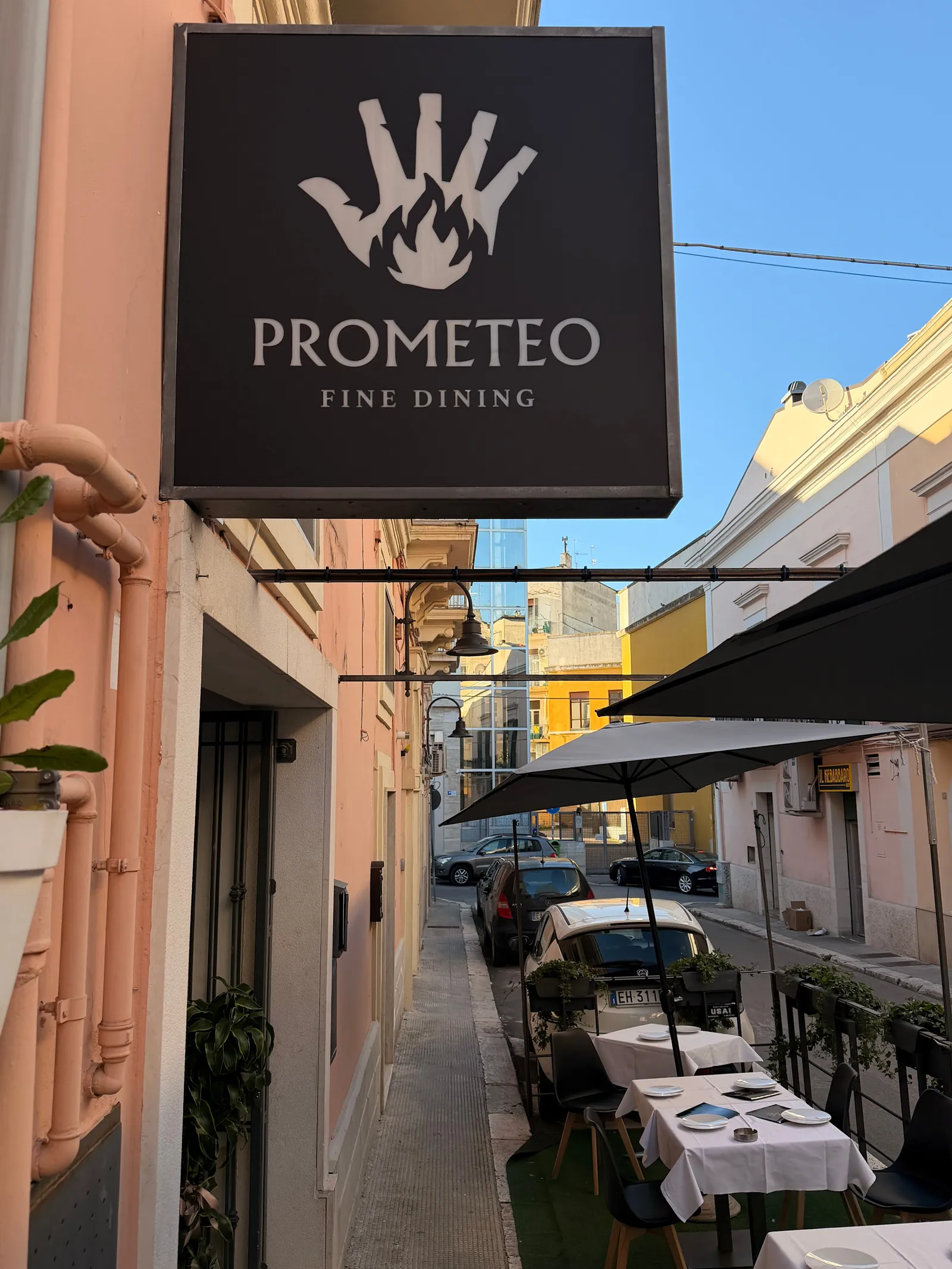 L'insegna e i tavoli all'aperto su via Torraca
